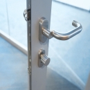 Lock and doorhandle in a fire resistant framed door EW30