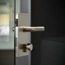 Vertical lock on a tampered glass door