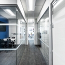 Corner of a single glass partition wall with tempered glass door