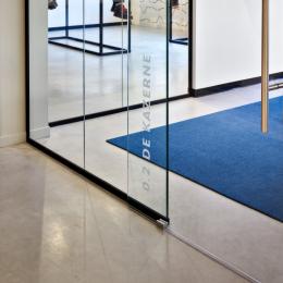 Detail of a glass sliding door in a glass partition wall system