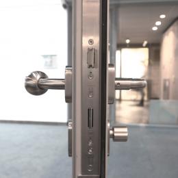 Lock and doorhandle in a fire resistant framed door EW30