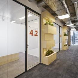Corridor / office dividing partitions wall made of acoustic laminated single glass and a framed door.