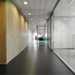 Corridor with on the right side IQ-Structural glass system wall with seamless panel joins.
