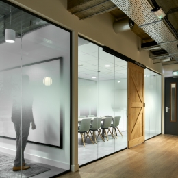 Offices with barn doors and glass partitions.
