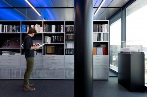Glass partition with a bookcase in front at The Flow Houthavens Amsterdam
